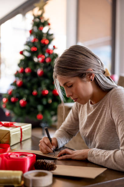 istock Woman at home writing a Christmas card 1713668582
