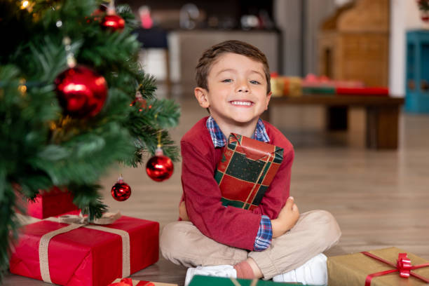 Happy boy opening his presents on Christmas morning