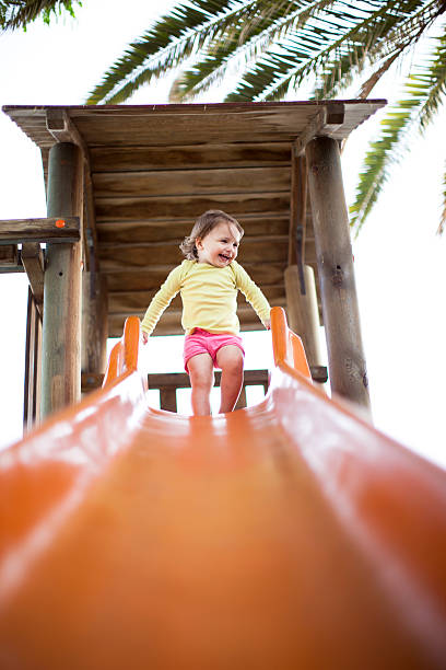 ребенок девочка на слайд. - babies and children cheerful low angle view vertical стоковые фото и изображения