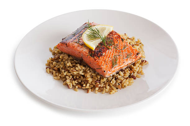 Salmon dish Salmon and brown rice dish on white background grilled salmon stock pictures, royalty-free photos & images