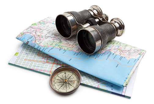 Map, compass and binoculars on white background. Map shows the Pacific coast of California.