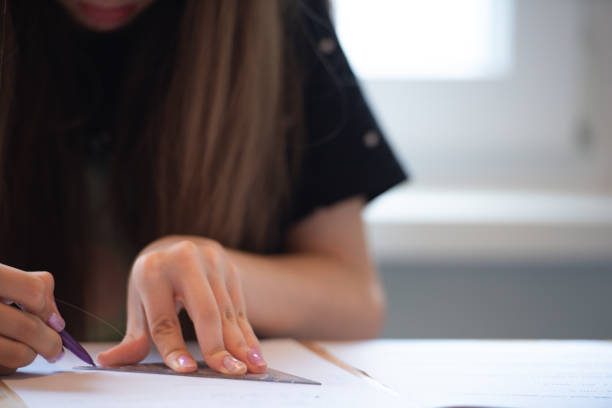 istock Teenage Girl at Home Sitting at Kitchen Table Working on Math Homework 1713688281