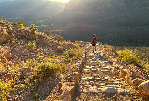 Grand Canyon, Arizona, USA - September 27, 2023: A young woman descends the South Kaibab trail at sunrise hiking into the Grand Canyon in Grand Canyon National Park in Arizona.