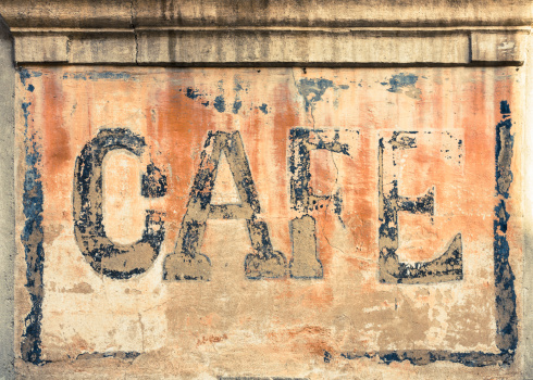 Old sign 'CAFE' on a wall of building.