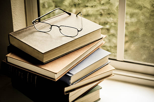 istock Books and eyeglasses on shelf by window 171370067