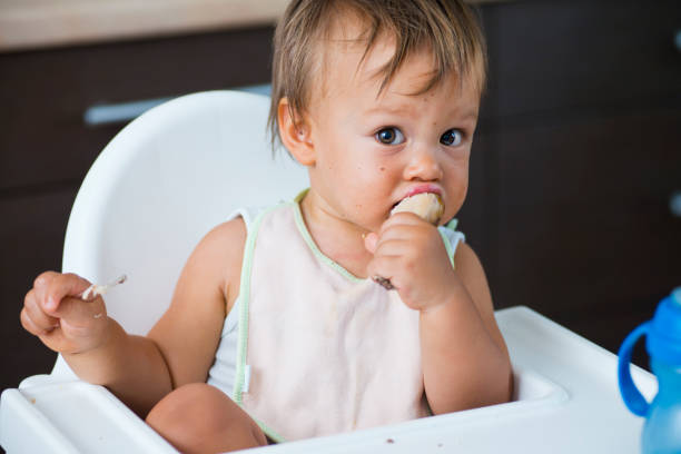 istock A toddler eating in a highchair  171370140