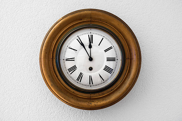 old wall clock showing five minutes to twelve stock photo