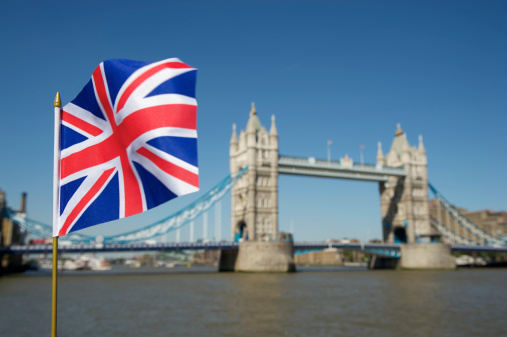 Union Jack British flag waves in bright sun at Tower Bridge London