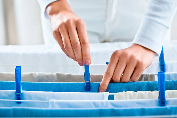 Woman Hanging Laundry to Dry Indoors
