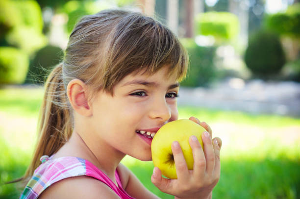 istock Smiling little girl eating apple 171370353