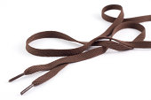 Pair of long brown shoe laces on a white background