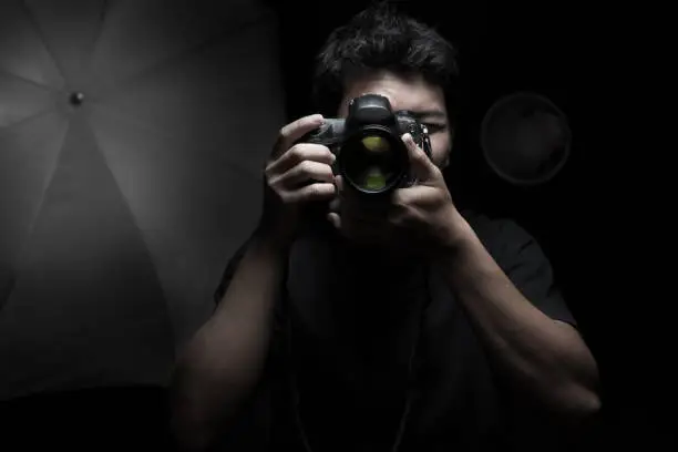 Photo of Photographer pointing DSLR camera towards camera