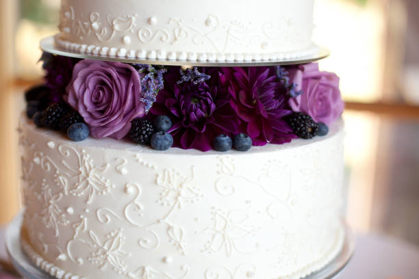 Wedding cake with purple flowers stock photo