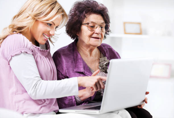 istock Daughter teaching her senior mother to use touchpad. 171371466
