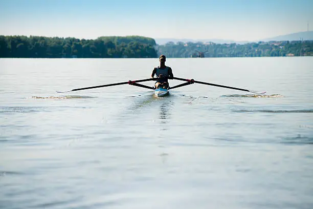 Young man rowing in boat at the river