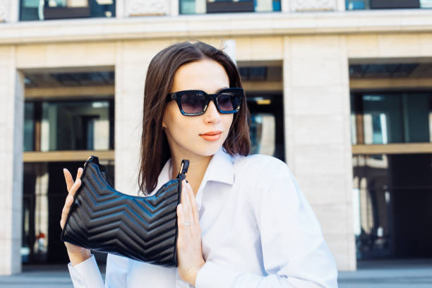 Stylish female model wearing sunglasses posing outdoor. Female fashion. stock photo