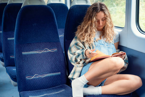 istock Woman reading a hardback book on a train journey 1713732569