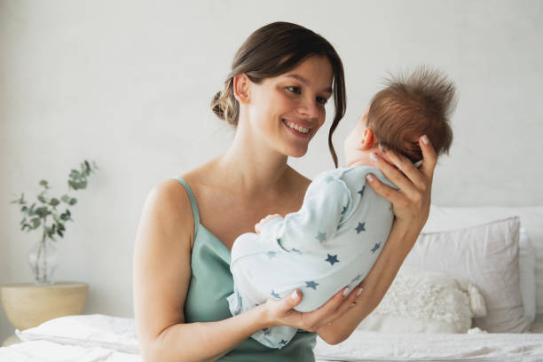 Loving mom carying of her newborn baby at home. stock photo