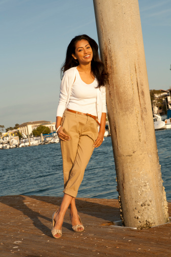 Beautiful ethnic woman enjoying the coast. View More: