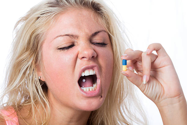 capelli biondi donna che mangia una pillola - pierced human tongue tongue stud teenager foto e immagini stock