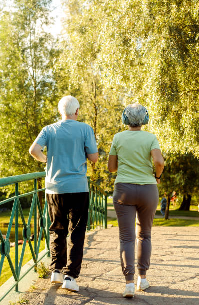 istock Smiling senior couple jogging in the park 1713741354