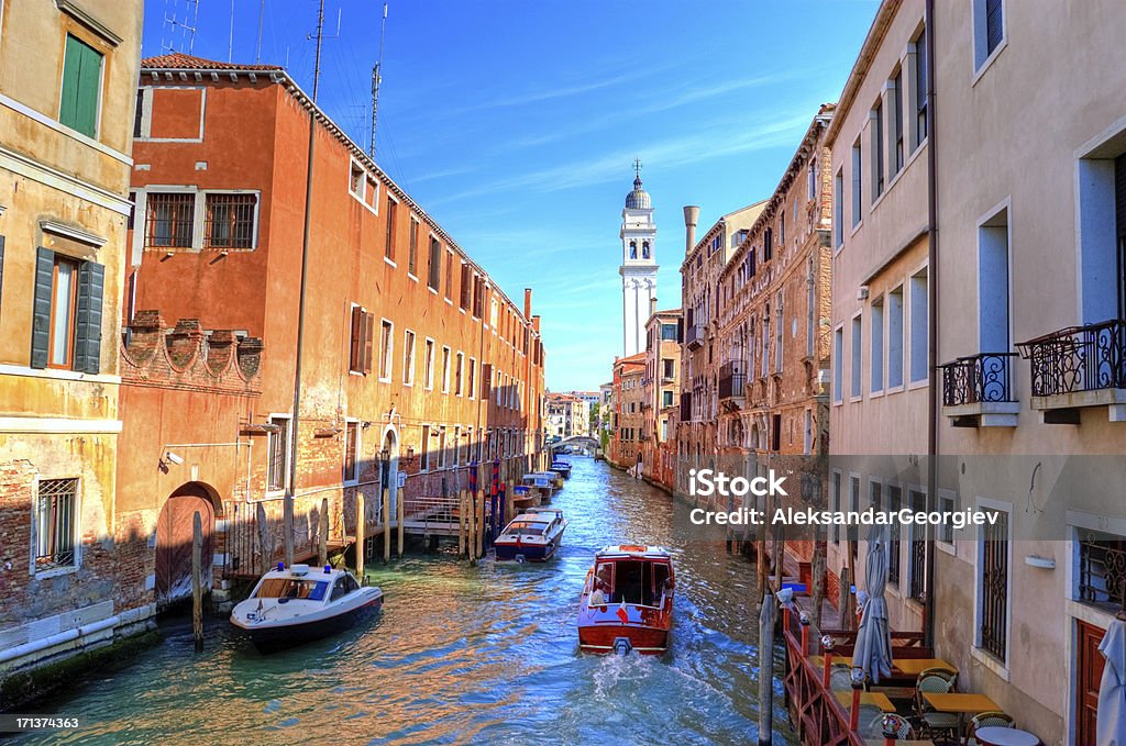 Colorful canal Venice, Italy "Beautiful view of colorful Canal in Venice, visible are boats, gondolas, restaurants, bridges, old bazaar, and Venetian traditional architecture. Venice, Italy." Bazaar Market Stock Photo