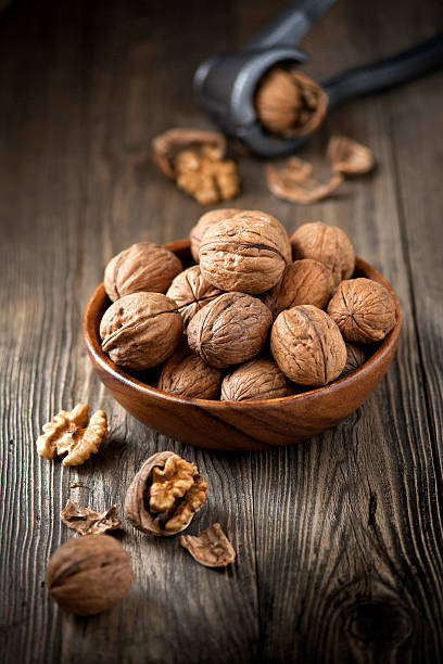 Bowl of walnuts Bowl of walnuts on wooden table walnut stock pictures, royalty-free photos & images