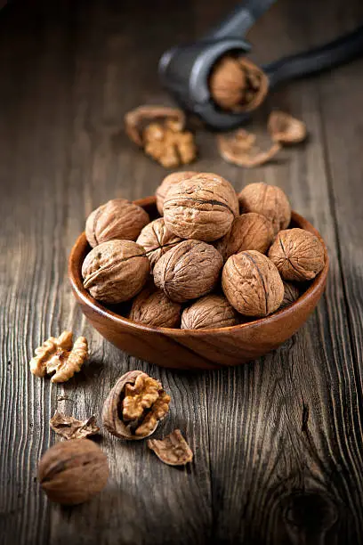 Bowl of walnuts on wooden table