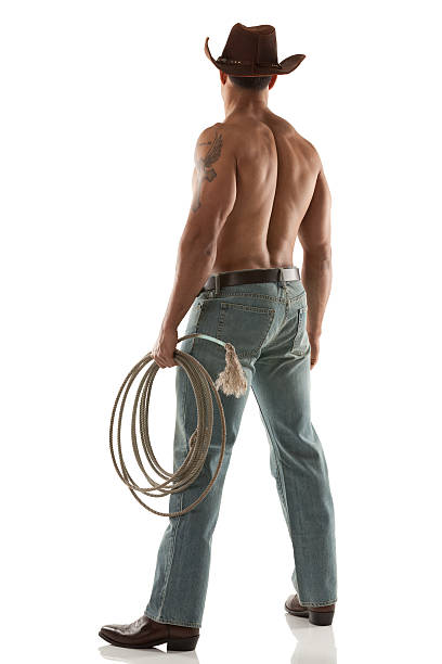 Cowboy standing with lasso Cowboy standing with lassohttp://www.twodozendesign.info/i/1.png body adornment rear view young men men stock pictures, royalty-free photos & images