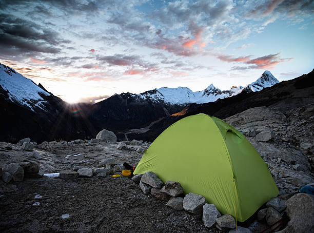 Young Asian man hiking by the tent.