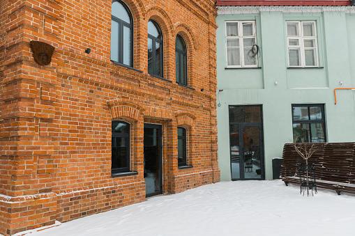 Street with houses cold weather. Snow day in winter. Building in city center covered with snow