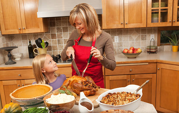 madre e bambini aiutando a servire giorno del ringraziamento turchia hz - turkey carving portion dinner foto e immagini stock