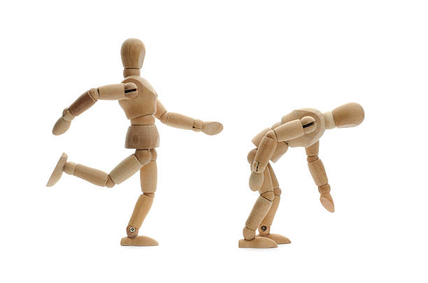 istock wooden mannequin kicking another in the butt 171376911