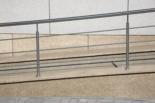 Ramp with metal handrail near building outdoors