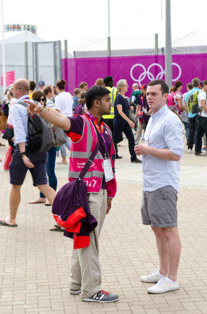 os jogos olímpicos de londres 2012 voluntário dar instruções sobre como chegar - sports event volunteer london england olympic park - fotografias e filmes do acervo