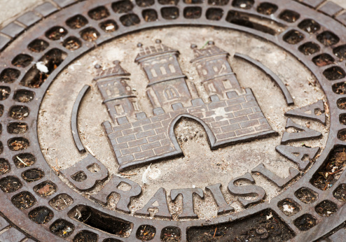 The historic castle coat of arms of the Slovakian city of Bratislava on a traditional manhole cover.