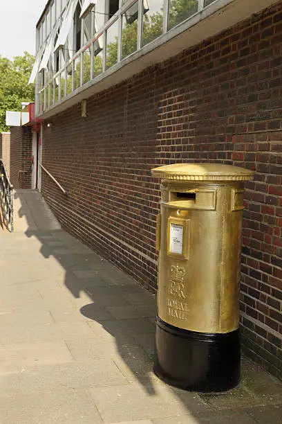 Photo of commemorative gold painted olympic post box in harlow essex england