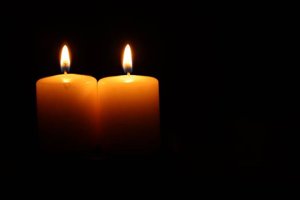istock Burning wax candles on black background, closeup. Space for text 1713780518