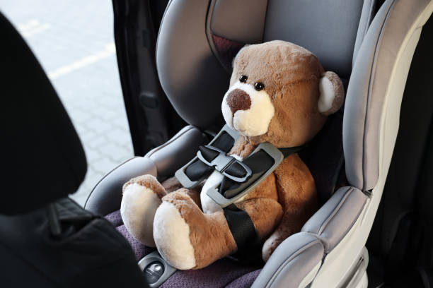 istock Teddy bear in child safety seat inside car 1713780699