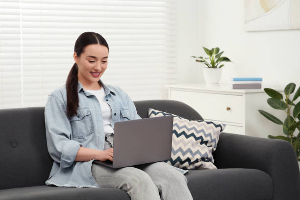 istock Woman using laptop on couch at home 1713783670