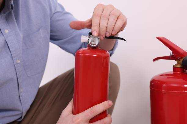 istock Man checking quality of fire extinguishers indoors, closeup 1713787939
