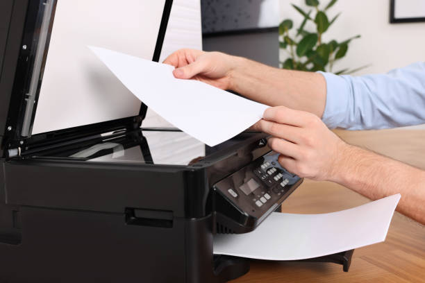 istock Man using modern printer at wooden table indoors, closeup 1713789094