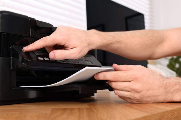 istock Man using modern printer at wooden table indoors, closeup 1713789126