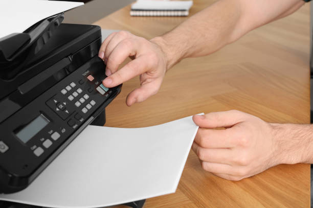 istock Man using modern printer at wooden table indoors, closeup 1713789166