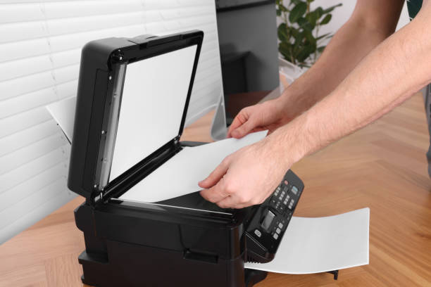 istock Man using modern printer at wooden table indoors, closeup 1713789683