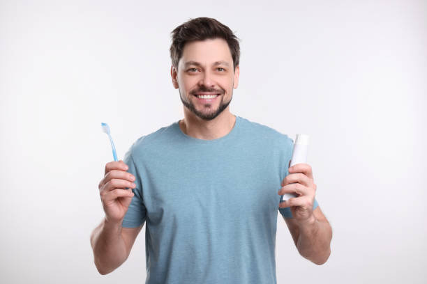 istock Happy man holding plastic toothbrush on white background. Mouth hygiene 1713790881