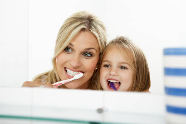 istock Mother And Daughter Brushing Teeth Together 171379122