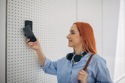 One woman, modern businesswoman using a smart phone to unlock the door.