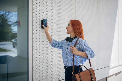 One woman, modern businesswoman using a smart phone to unlock the door.