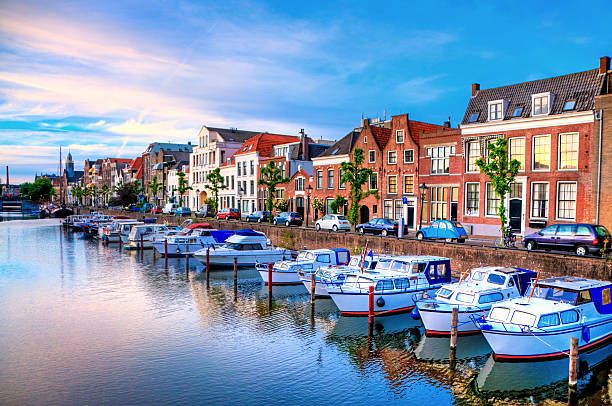 Rotterdam's Delfshaven with his Historic Buildings "Historic cityscape along a channel in Delfshaven, a district of Rotterdam, the Netherlands. Visible are typical dutch architecture, historic sailing boats,windmill, restaurants, colorful reflection in the river, blue and dramatic cloudscape and beautiful sunset atmosphere." gable photos stock pictures, royalty-free photos & images